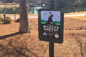 A sign displays the Certified Wildlife Habitat at the lake.